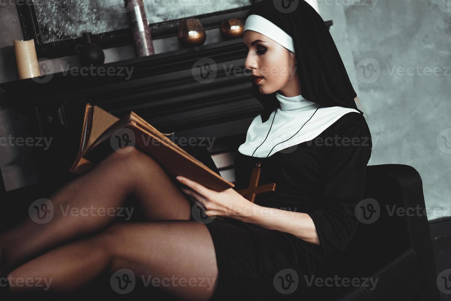 belle jeune nonne en costume noir de religion détient la bible. religion photo