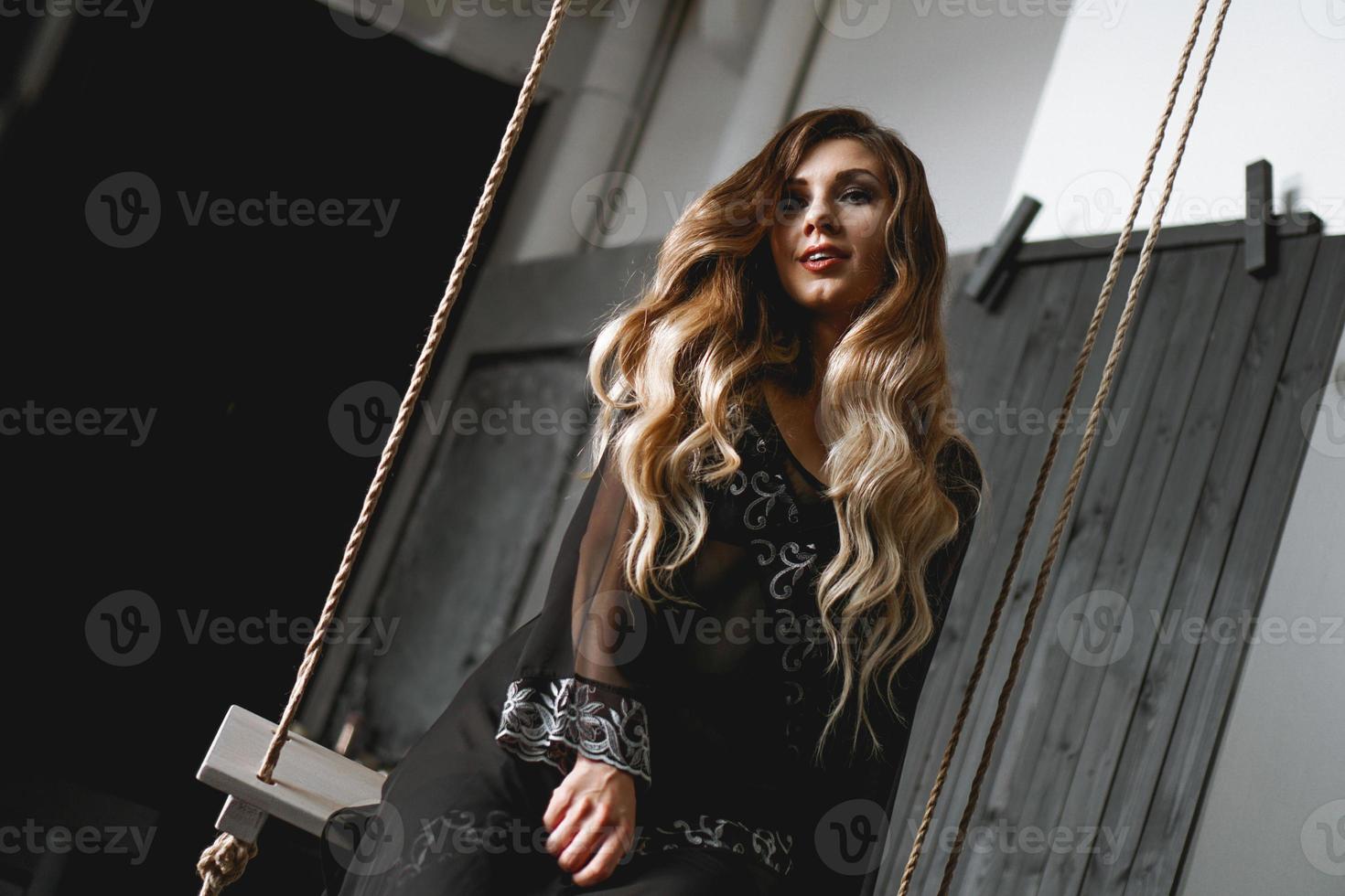 Jeune jolie femme, portant un peignoir noir transparent dans une pièce sombre photo