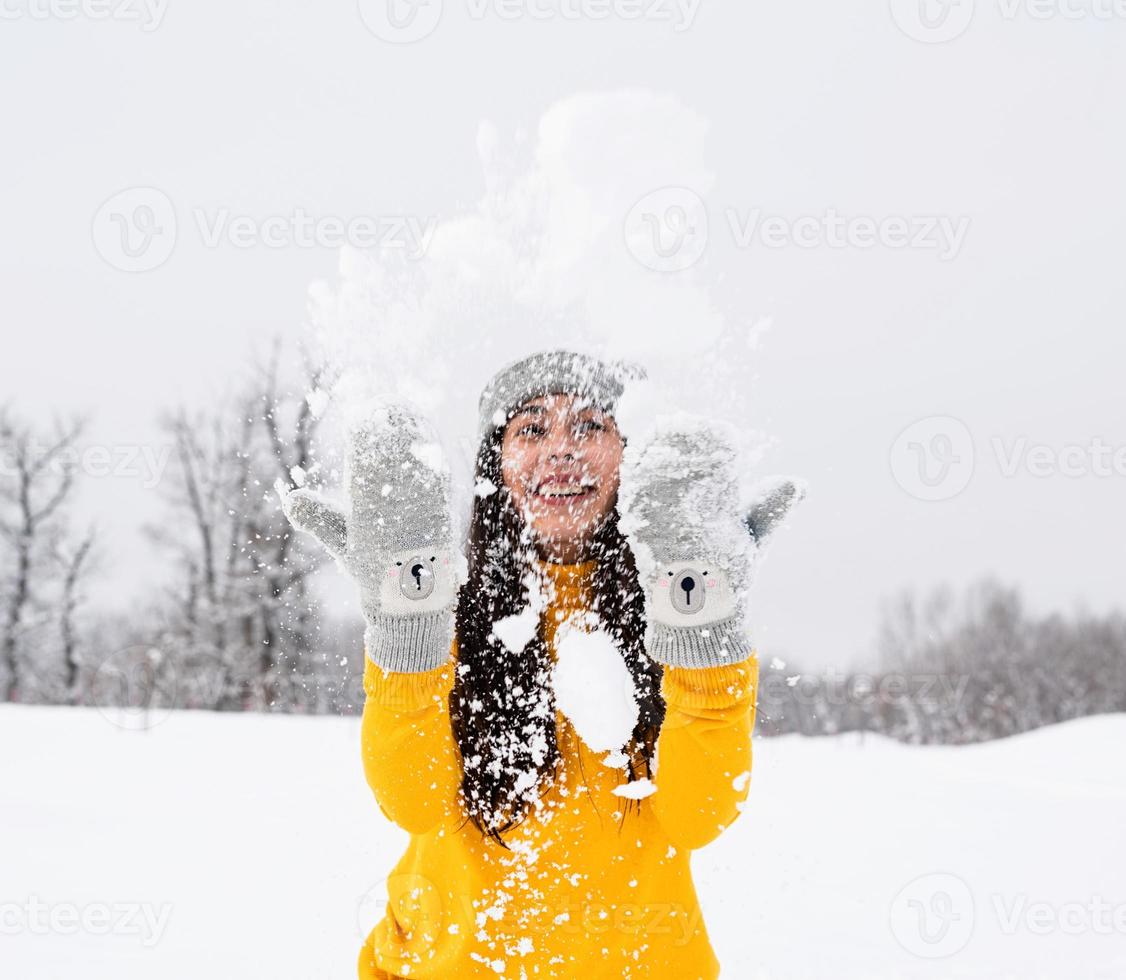 Jeune femme brune jouant avec de la neige dans le parc photo