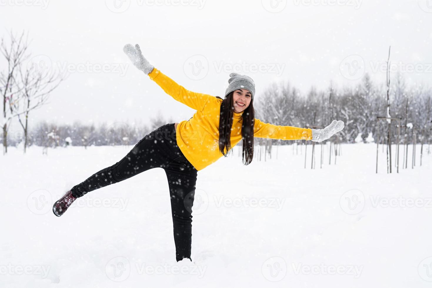 Jeune femme brune jouant avec de la neige dans le parc photo