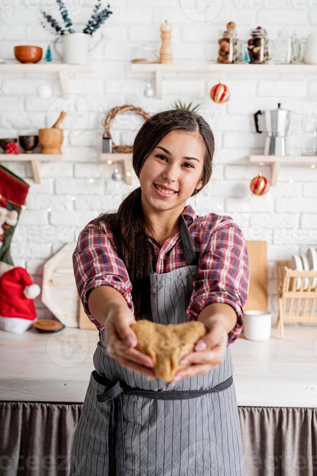 Happy brunette woman holding pâte en forme de coeur à la cuisine photo