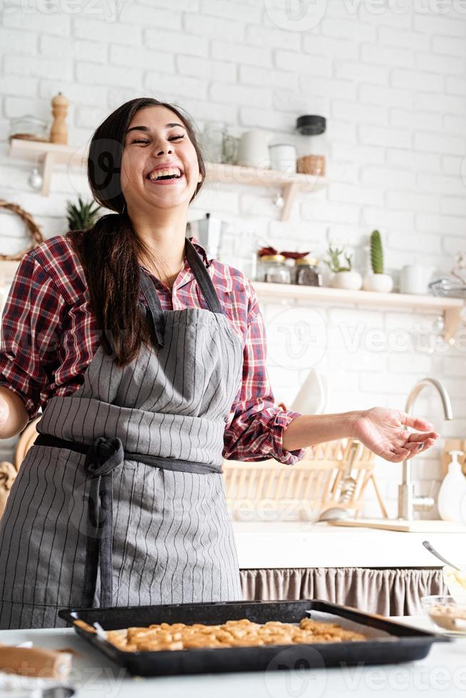 Jeune femme brune préparant des biscuits à la cuisine photo