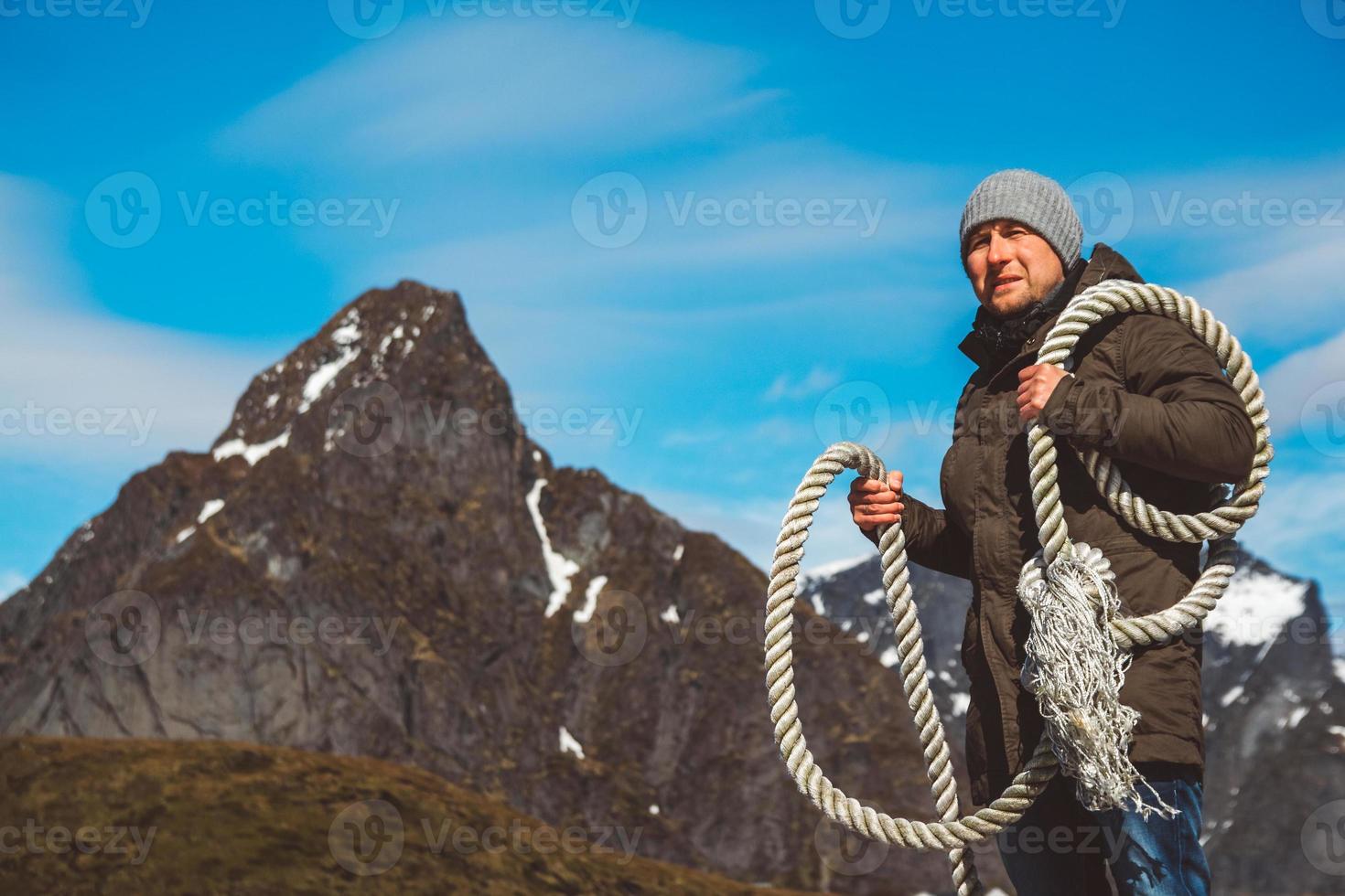 homme avec une corde sur son épaule sur fond de montagnes photo