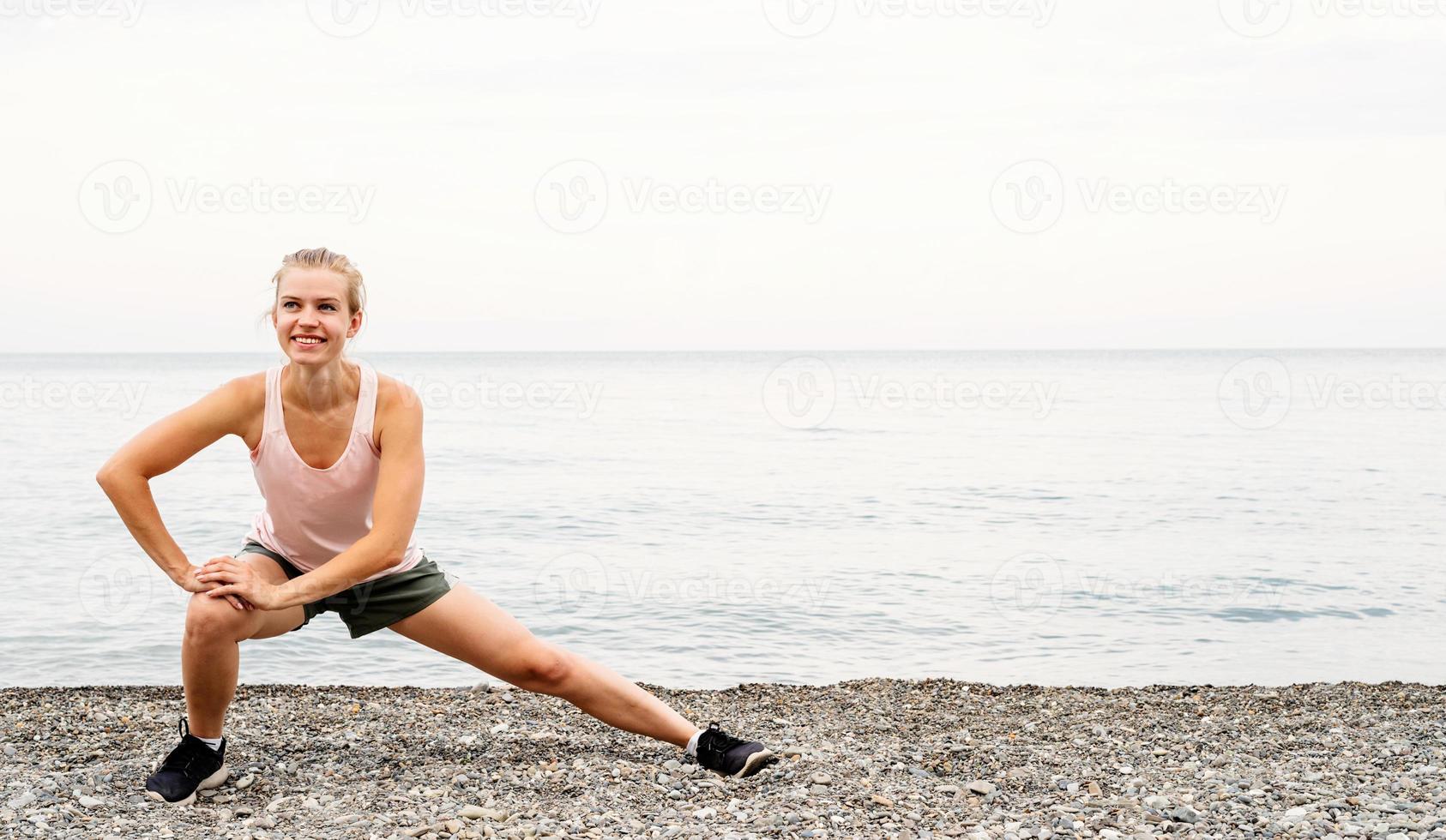 femme athlète blong faisant des exercices à la plage photo