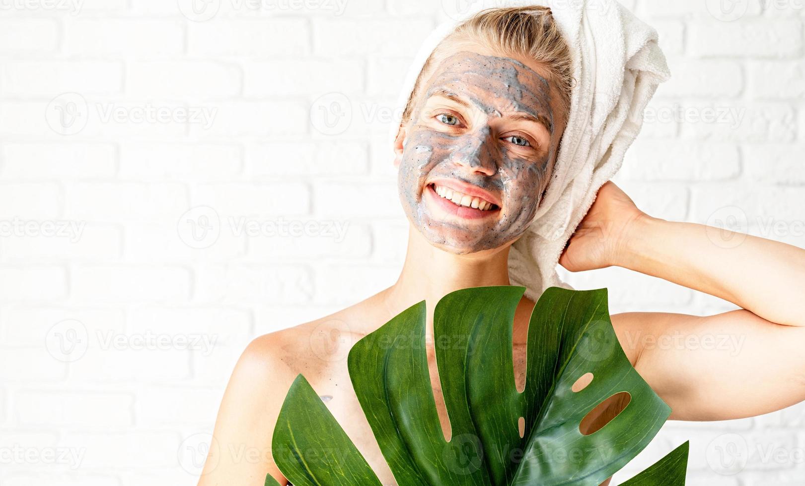 femme souriante heureuse sur son visage tenant une feuille verte de monstera photo