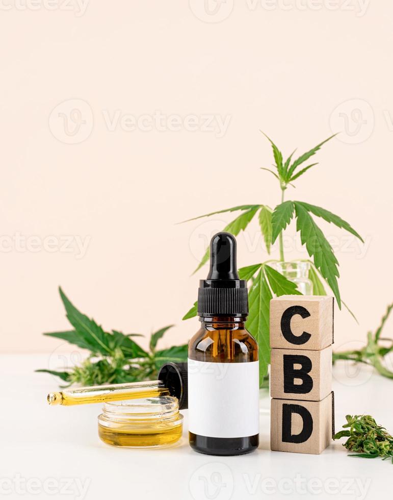 l'huile de CBD et le cannabis laisse la vue de face des cosmétiques sur fond orange photo