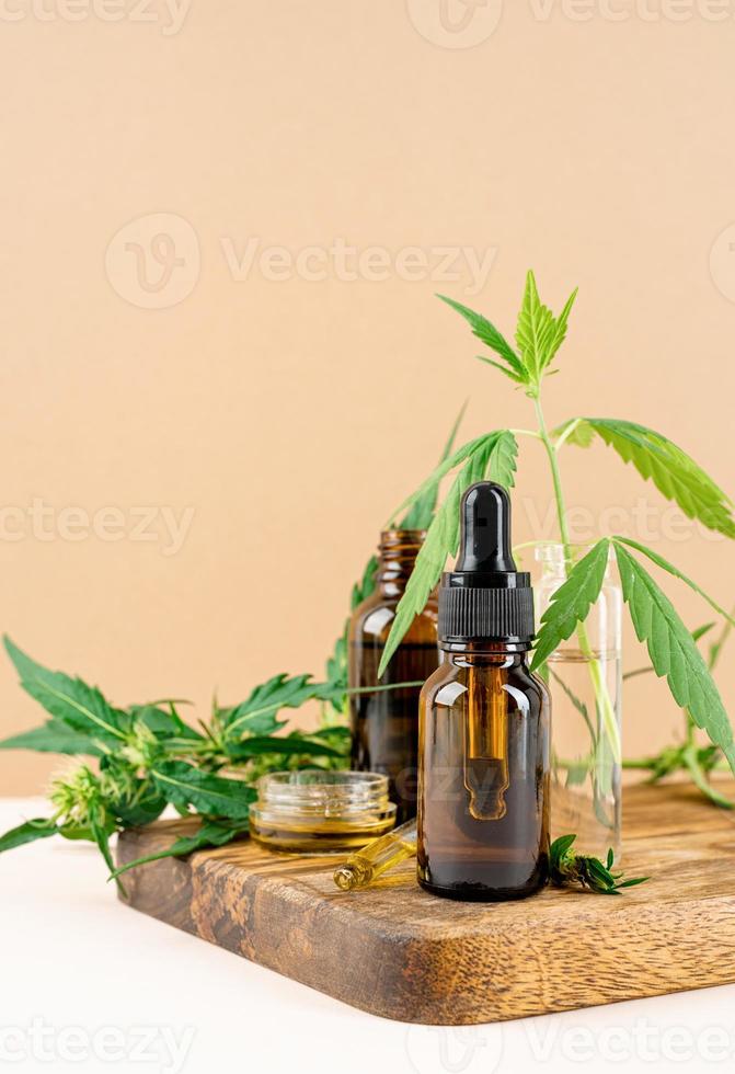 l'huile de CBD et le cannabis laisse la vue de face des cosmétiques sur fond orange photo