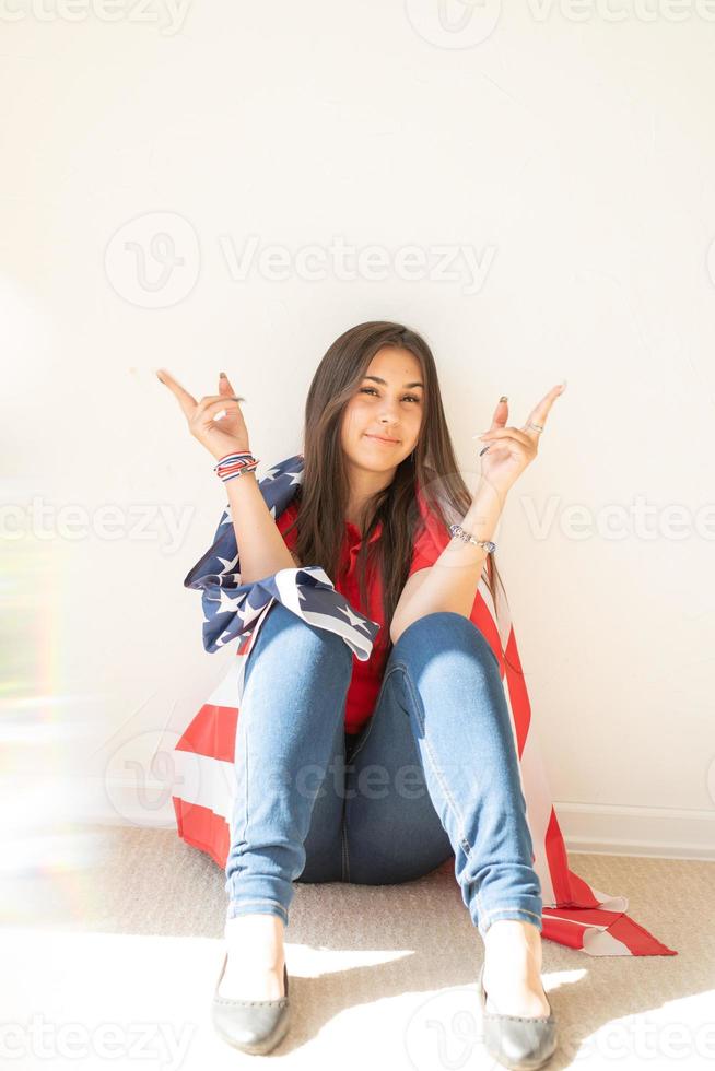 belle jeune femme avec drapeau américain sur fond blanc photo