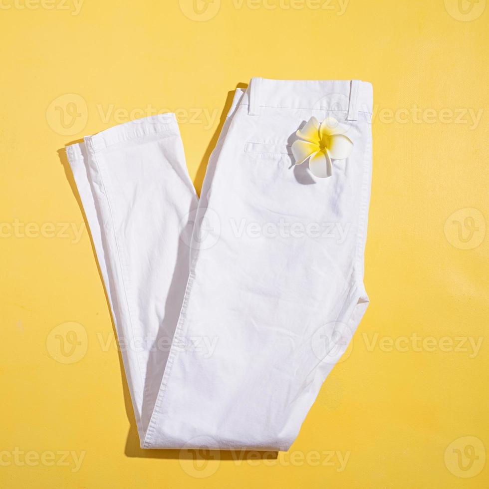 jeans d'été blanc avec fleur de plumeria sur fond blanc photo