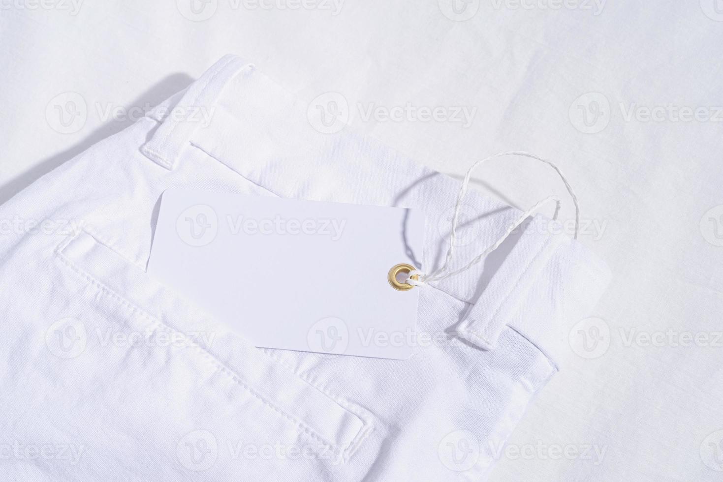 jeans d'été blanc sur fond de tissu blanc avec étiquette de prix vierge photo