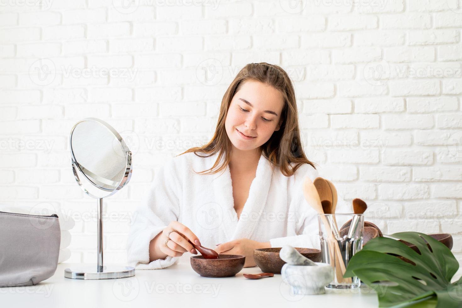 femme portant des peignoirs faisant des procédures de spa à l'aide de cosmétiques naturels photo