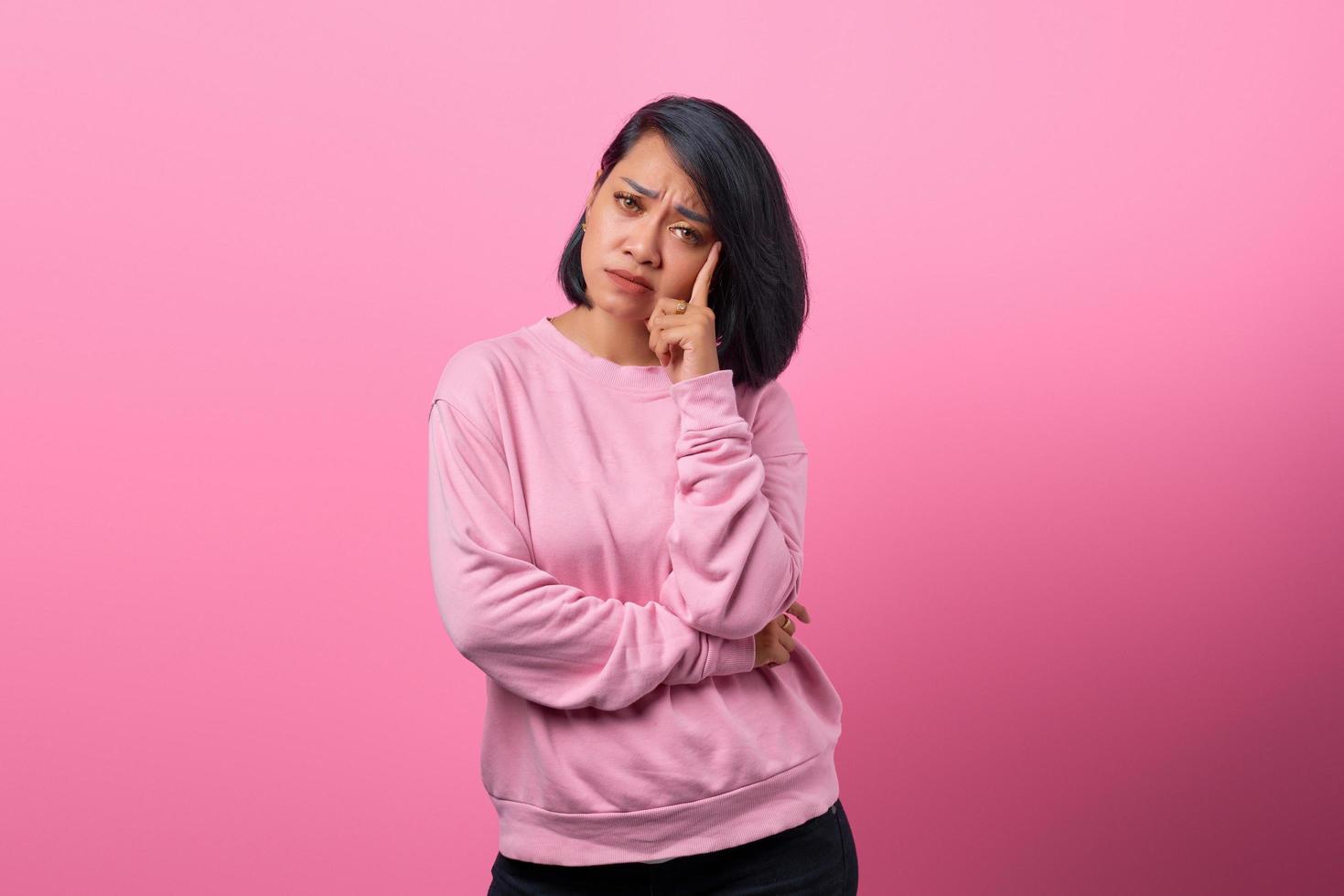 jeune belle femme mains près du visage, pensant, concentrée sur la tâche. photo