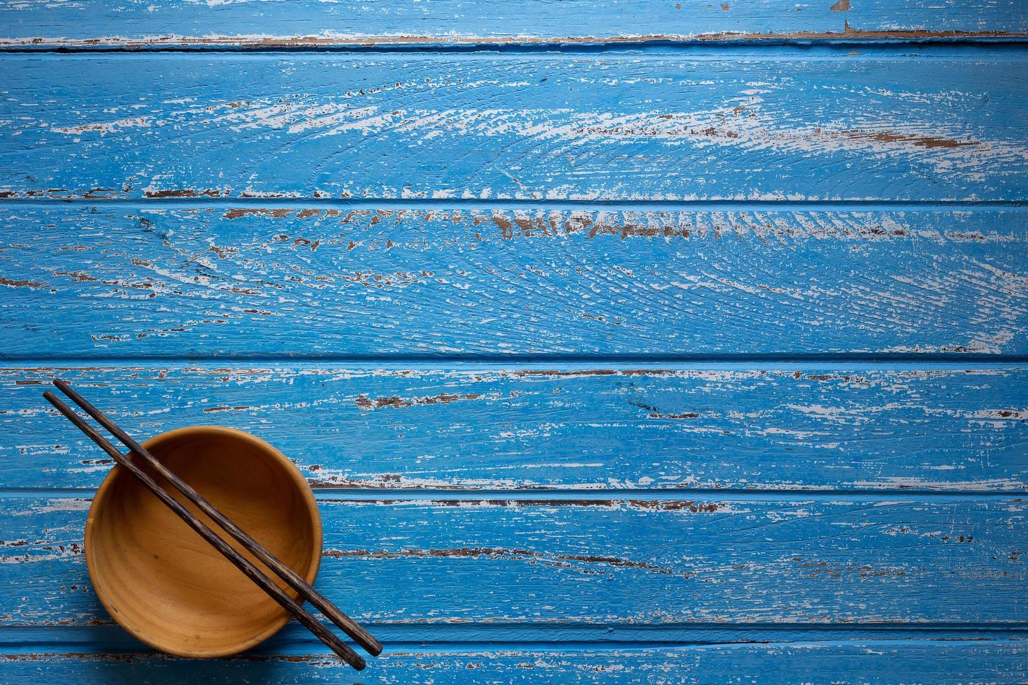 baguettes et bols en bois vides sur fond de table bleu photo