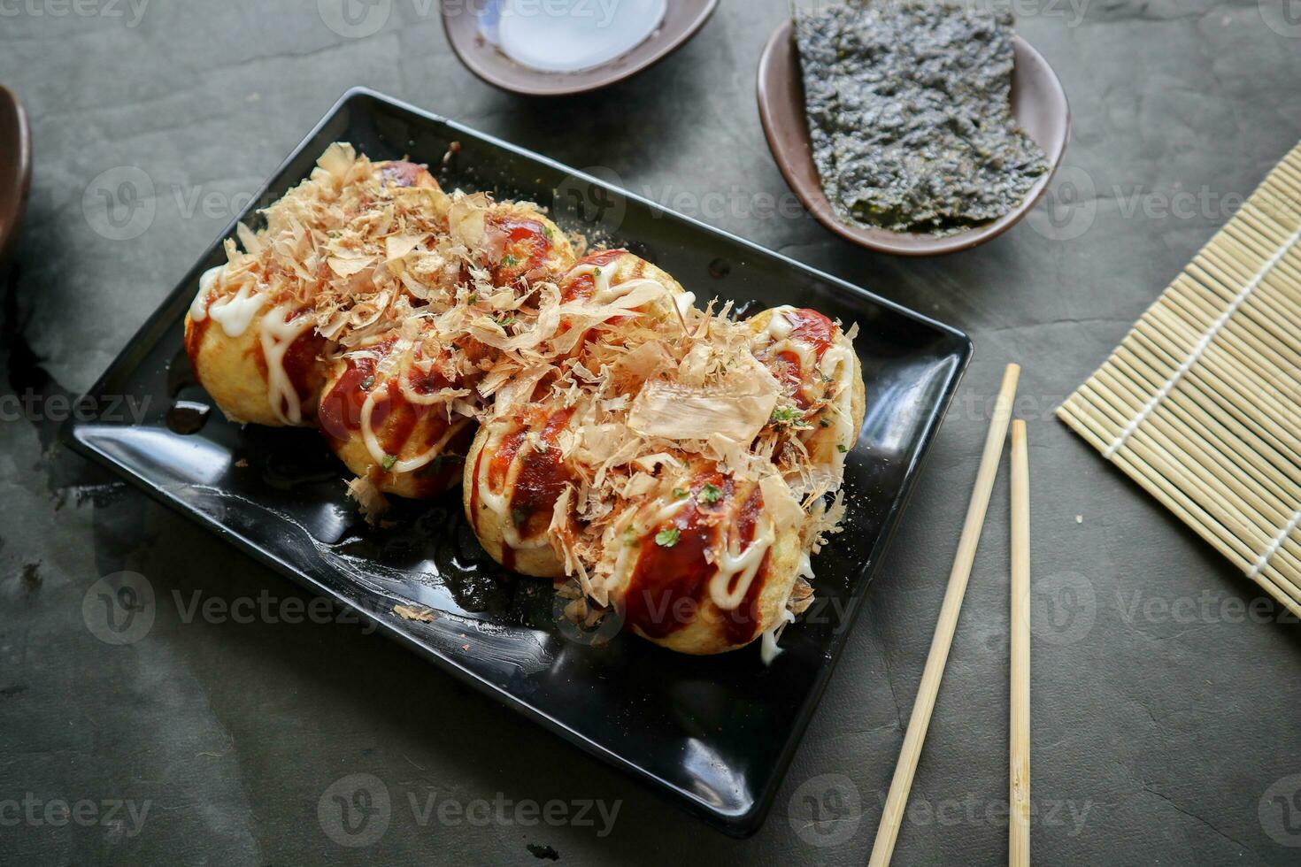 takoyaki est une Japonais nourriture, fabriqué de blé farine pâte, poulpe Viande, ou autre remplissages, servi avec sauce, Mayonnaise et Garniture dans le forme de katsuobushi ou bois poisson copeaux. photo