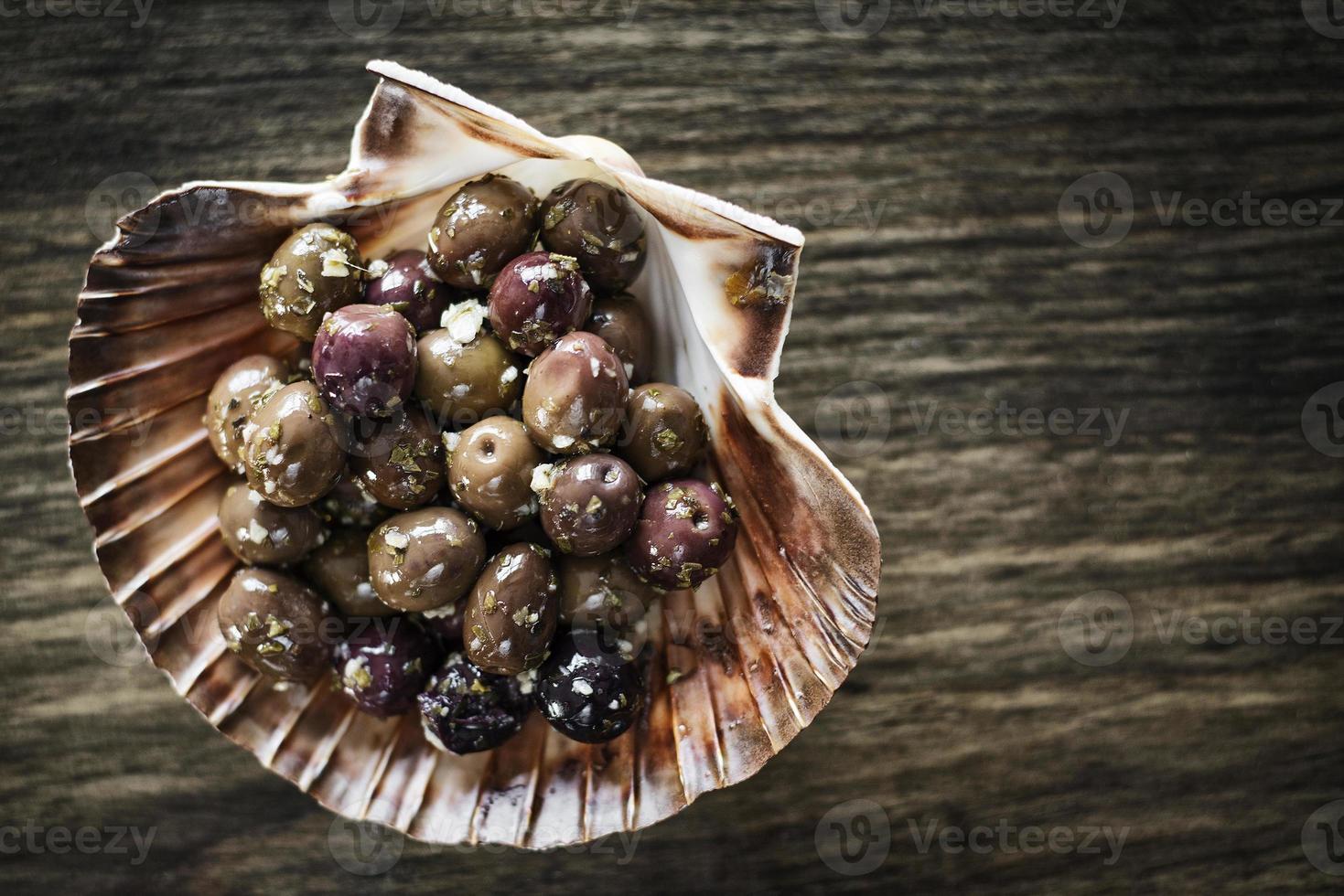 Entrée gourmande de tapas aux olives fraîches marinées à l'ail et aux herbes photo