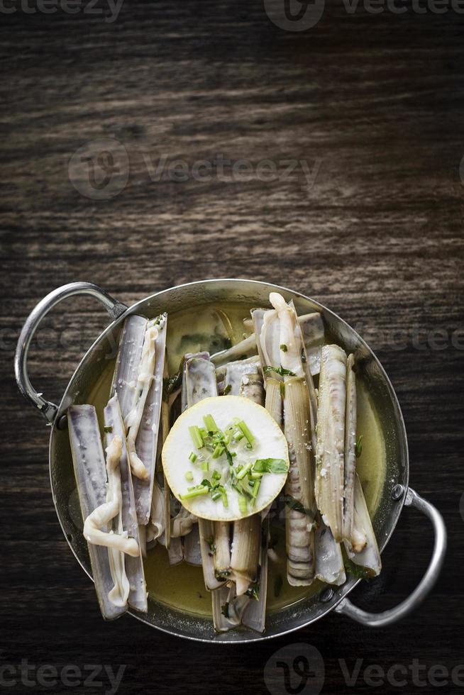 Fruits de mer frais de coquille de rasoir portugais cuits à la vapeur dans une sauce au vin blanc aux herbes et à l'ail photo