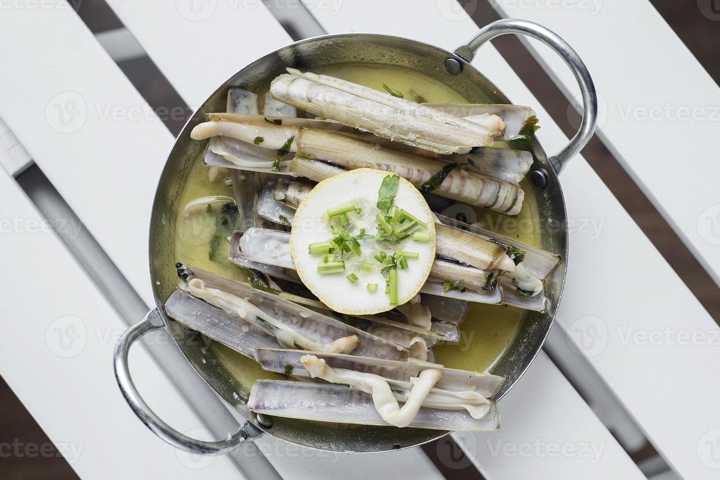 Fruits de mer frais de coquille de rasoir portugais cuits à la vapeur dans une sauce au vin blanc aux herbes et à l'ail photo