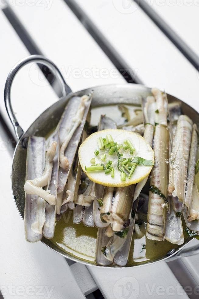 Fruits de mer frais de coquille de rasoir portugais cuits à la vapeur dans une sauce au vin blanc aux herbes et à l'ail photo