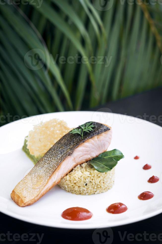 Cuisine fusion gastronomique filet de poisson saumon avec guacamole et repas de riz au curcuma photo