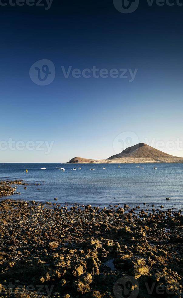 plage touristique d'el medano et paysage célèbre du montana roja à tenerife en espagne photo