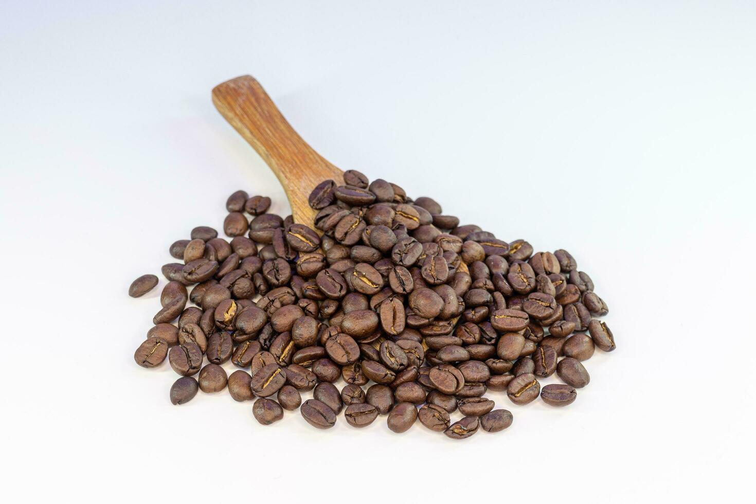 café des haricots sur une en bois cuillère isolé sur une blanc Contexte. photo