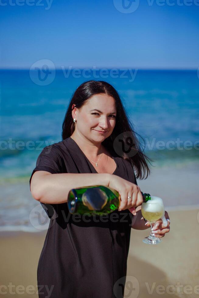 une fille avec Champagne sur le rivage photo