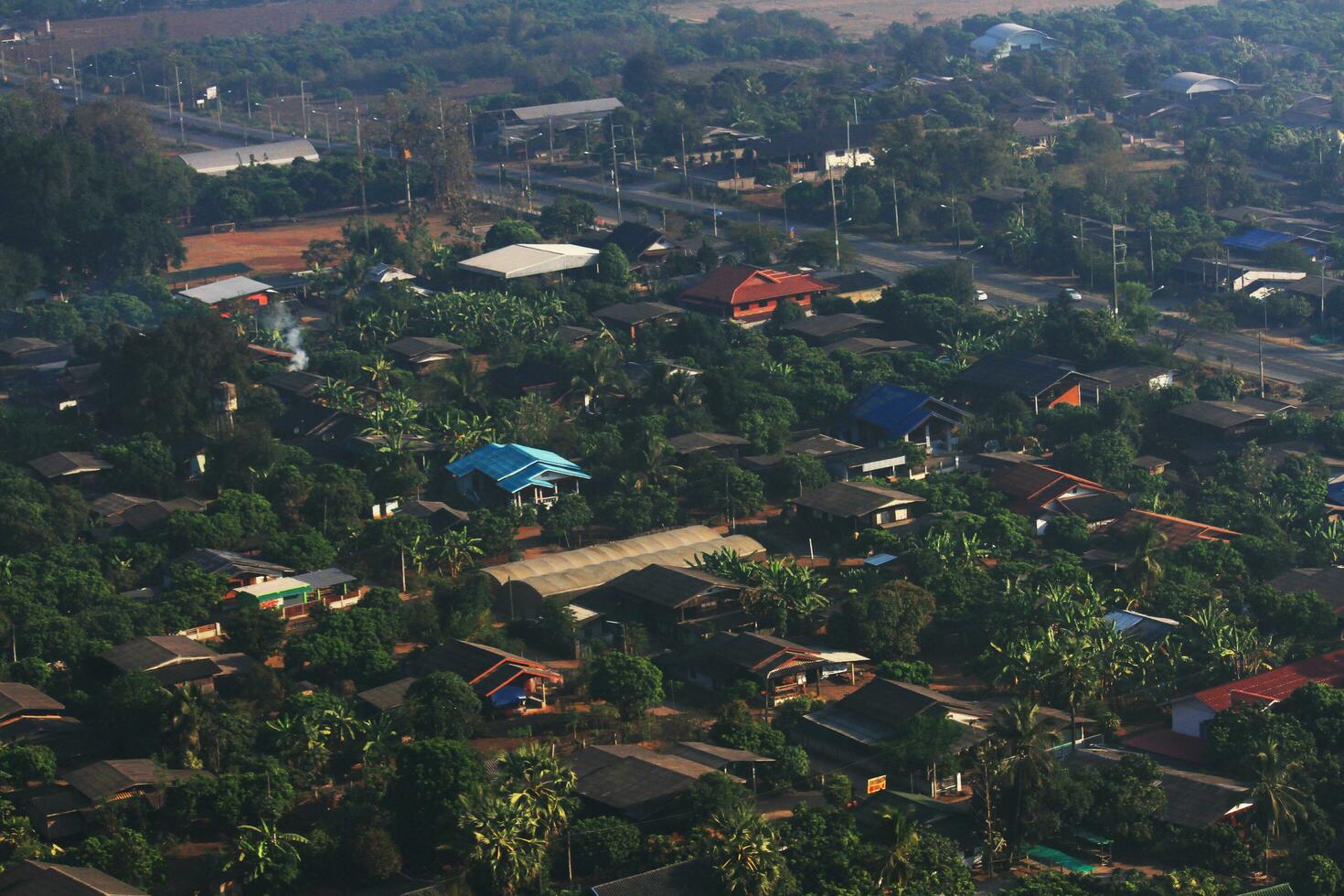 aérien vue de toits de vert champ avec village Maisons dans le campagne dans nord de Thaïlande. photo