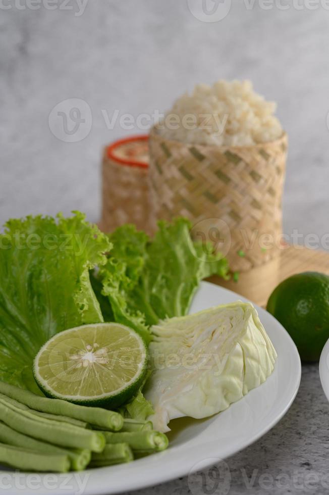 salade de chou vert, citron vert, haricots verts sur une assiette blanche photo