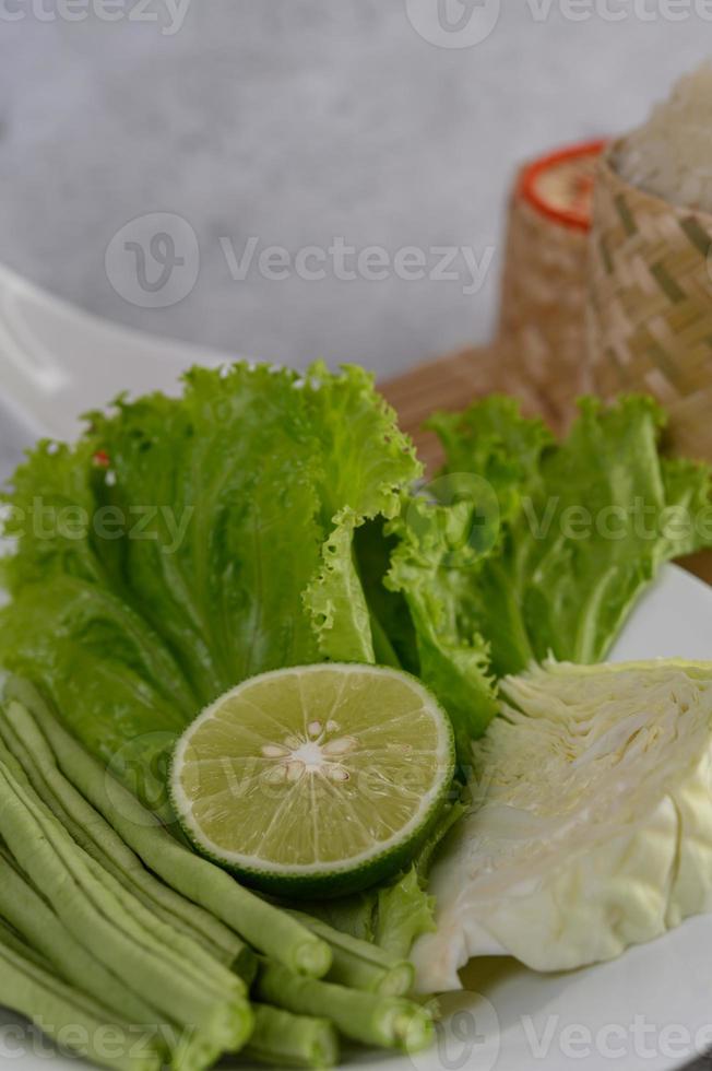 salade de chou vert, citron vert, haricots verts sur une assiette blanche photo