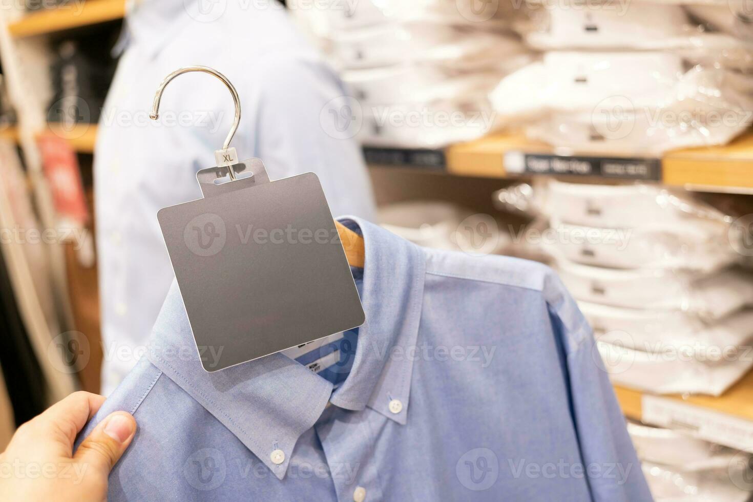 Vide étiquette avec vêtements pendre sur une étagère dans une designer vêtements magasin. Vêtements pendaison sur une Vêtements grille dans une boutique photo