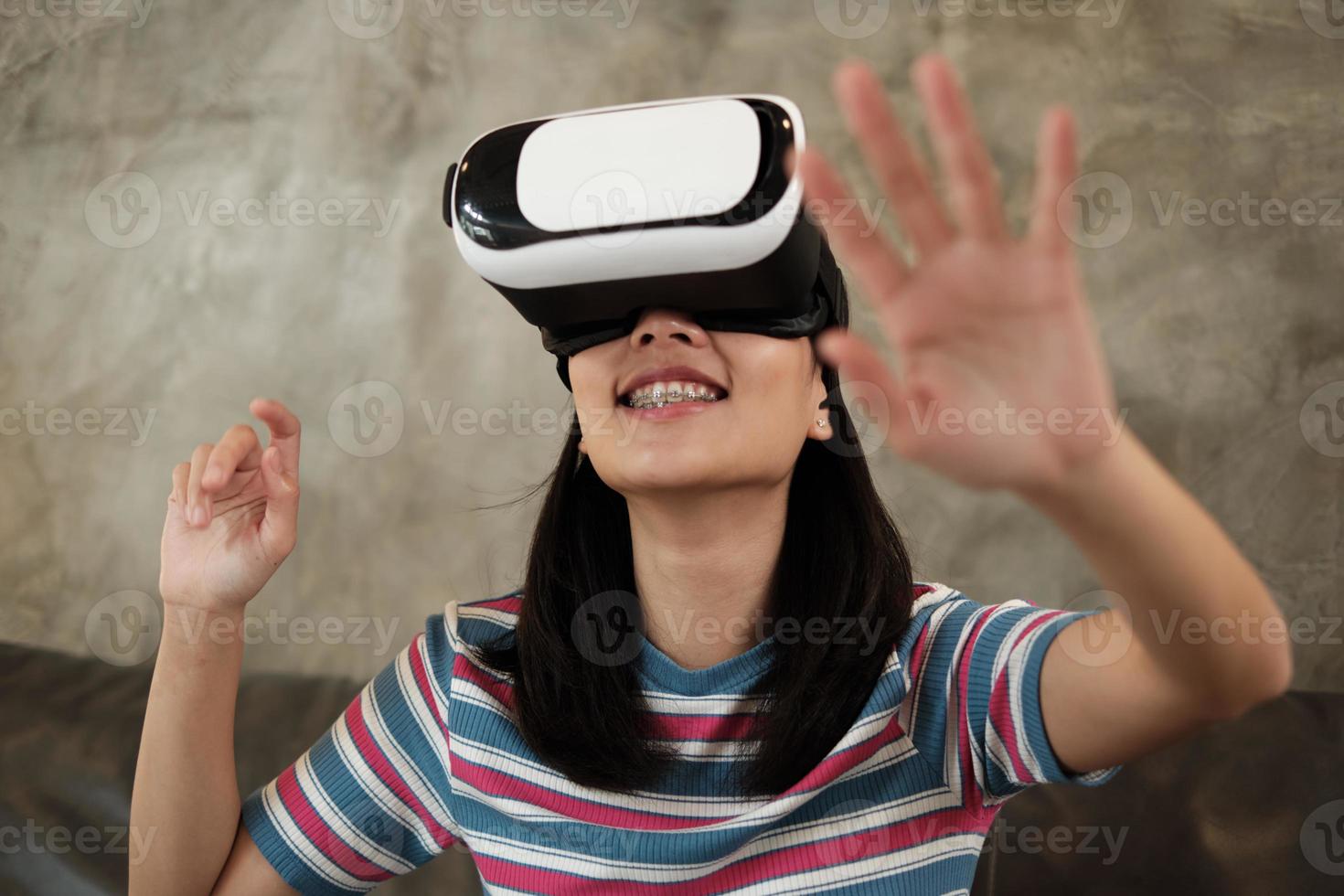 femme asiatique avec casque vr, regardant la simulation virtuelle 3d. photo