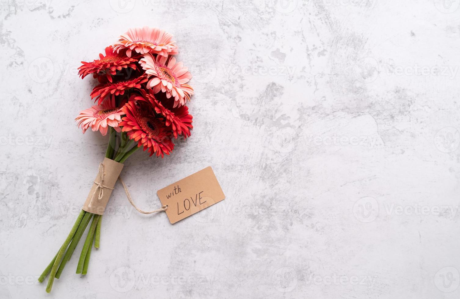 Fleurs de marguerite gerbera rouge et étiquette d'étiquette artisanale photo