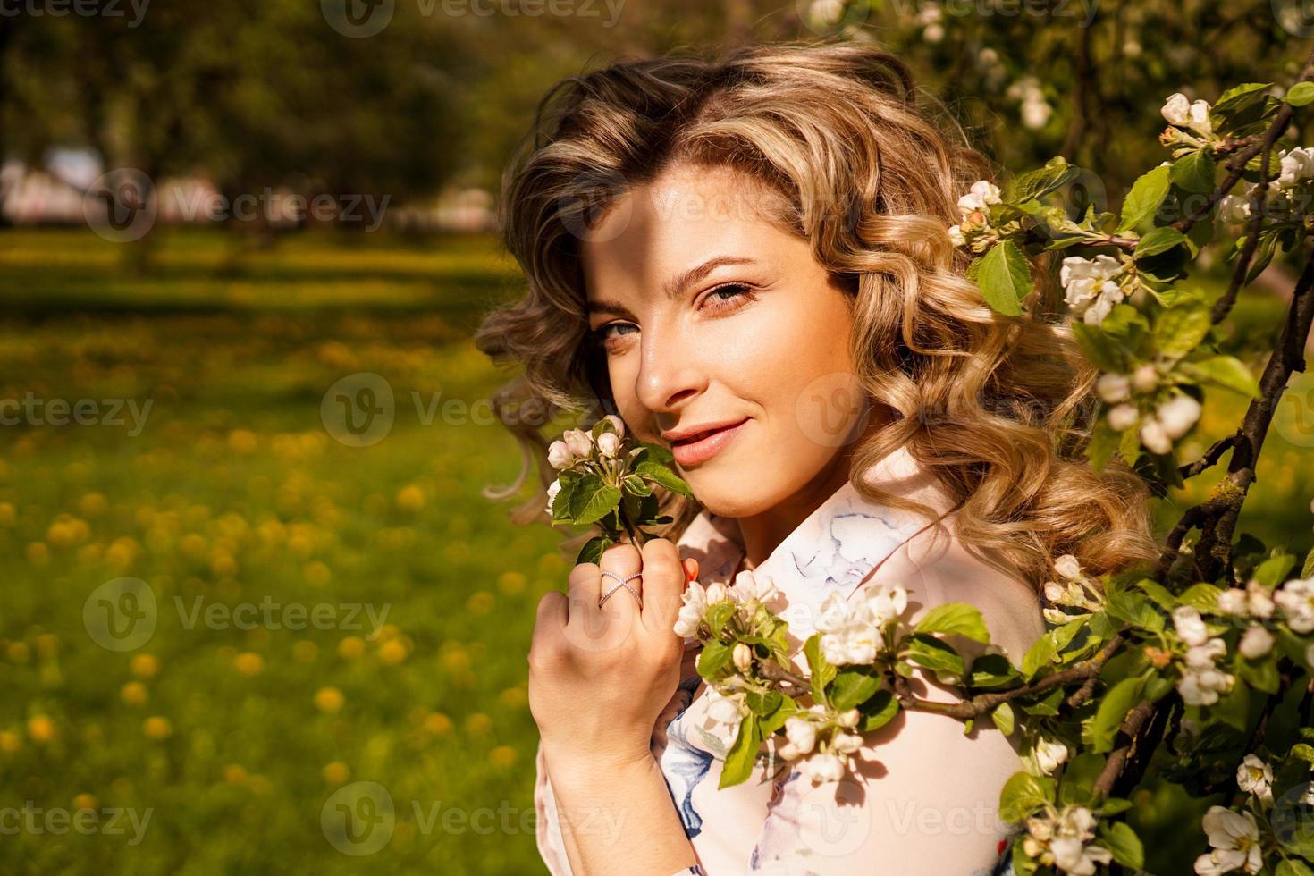 jeune femme romantique dans le jardin de printemps parmi la fleur de pommier. photo