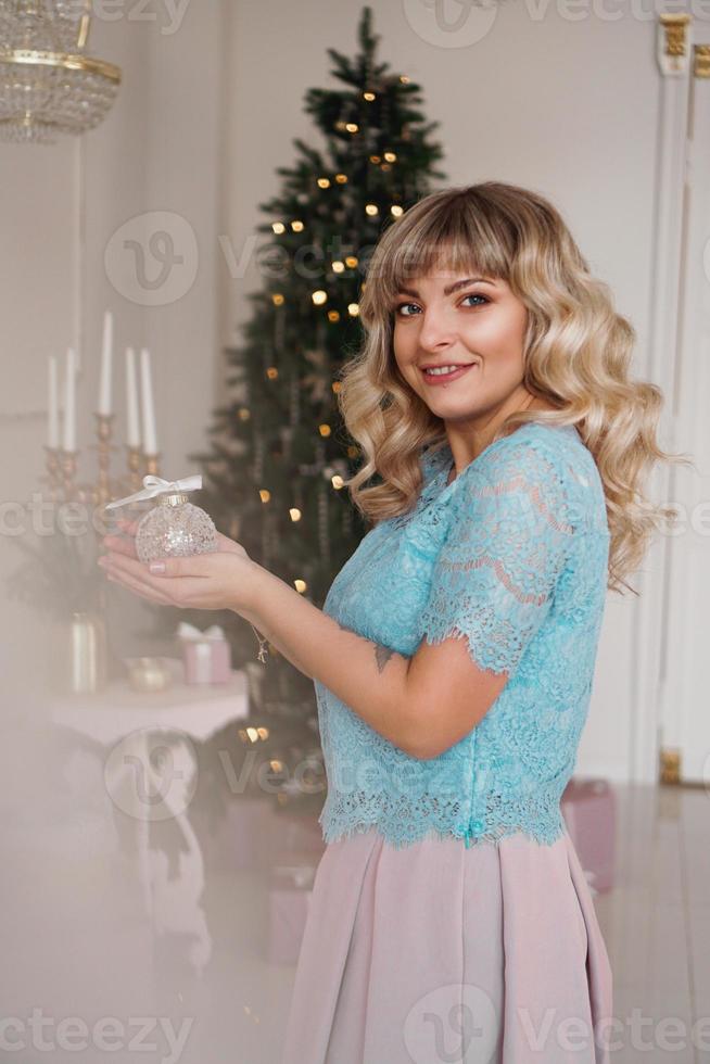 jeune femme décore l'arbre de noël avec des jouets de noël photo