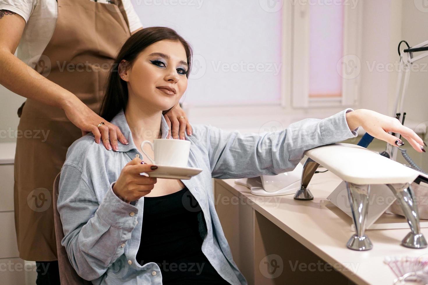 femme se faisant manucure et massage en même temps dans un salon photo