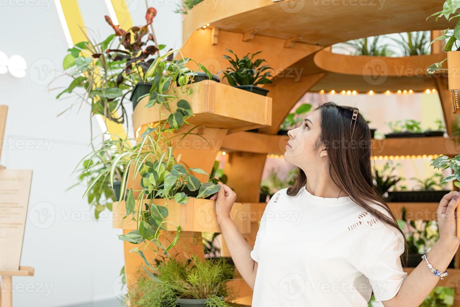 femme assise sur le canapé dans le centre commercial, regardant les plantes photo