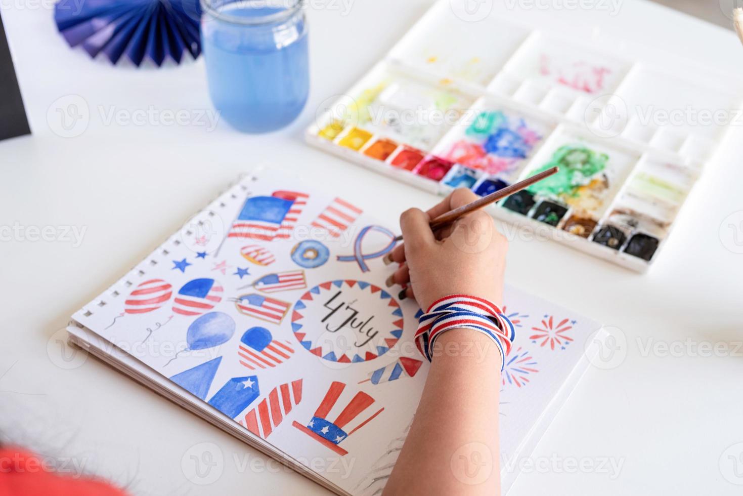 femme dessinant une illustration à l'aquarelle pour le jour de l'indépendance des états-unis photo