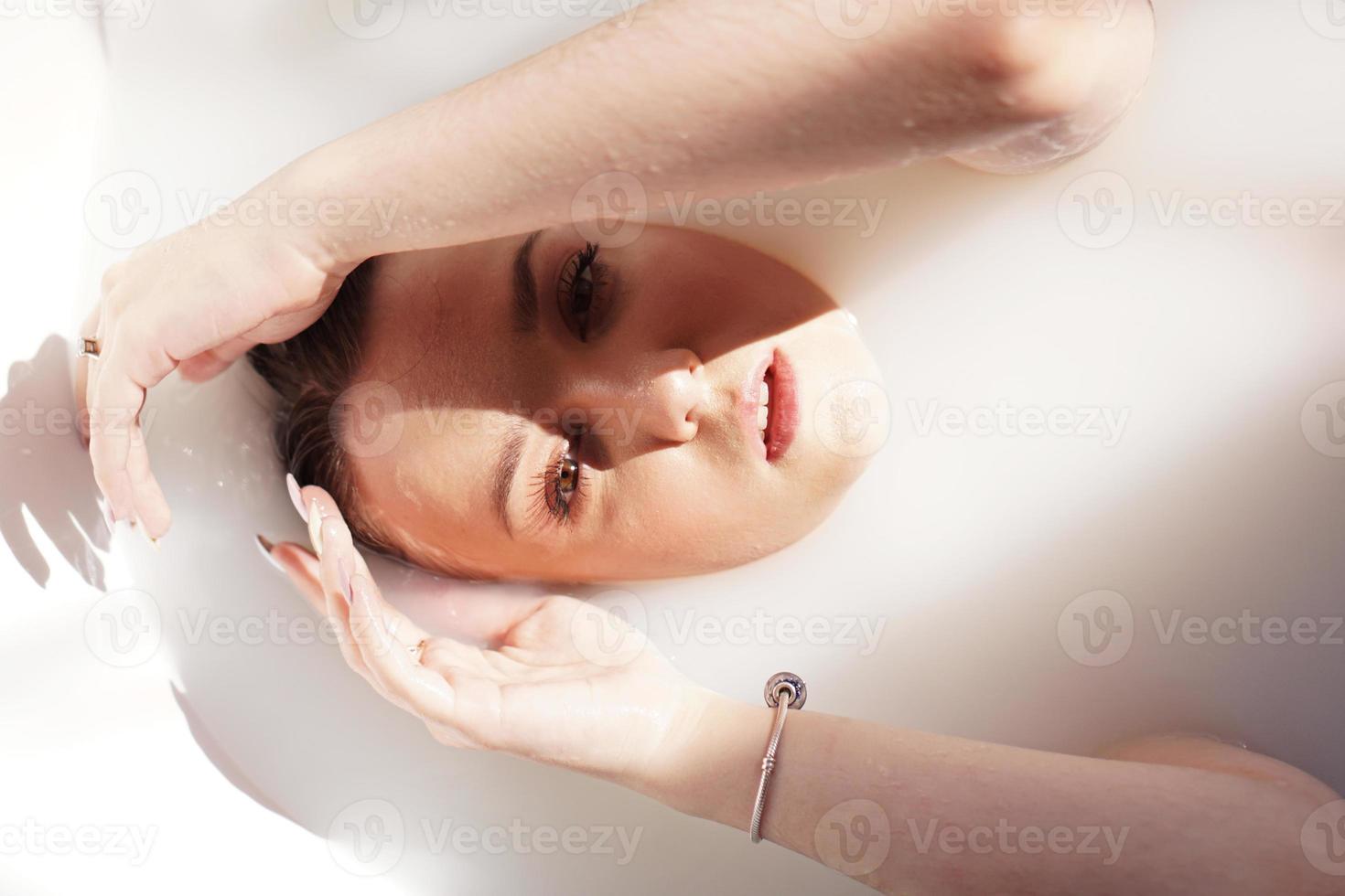 fille dans le bain avec du lait. cures thermales pour le rajeunissement de la peau. photo