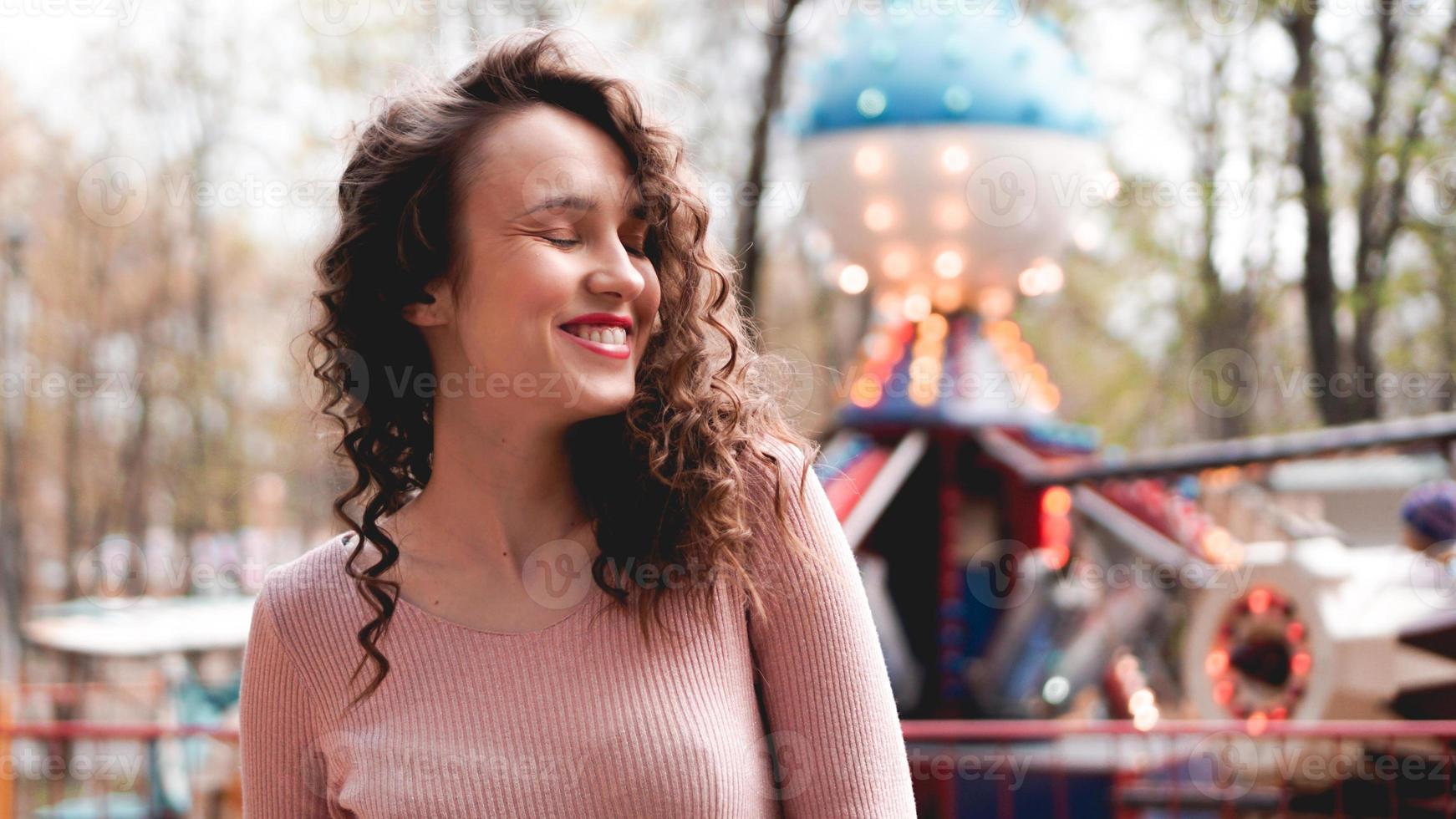 fille se détendre dans un parc d'attractions le matin. modèle féminin en riant photo