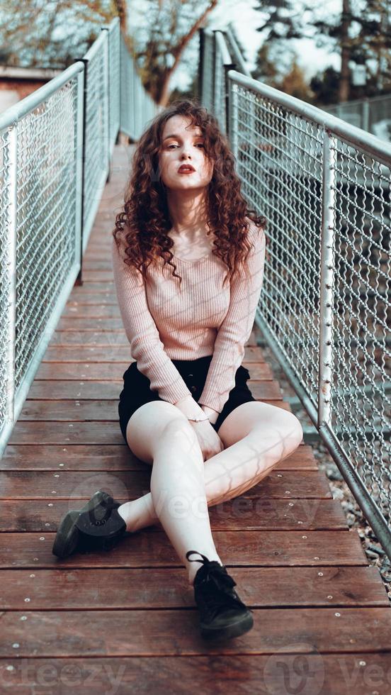 portrait de mode d'une jeune femme branchée assise près du filet rabitz photo