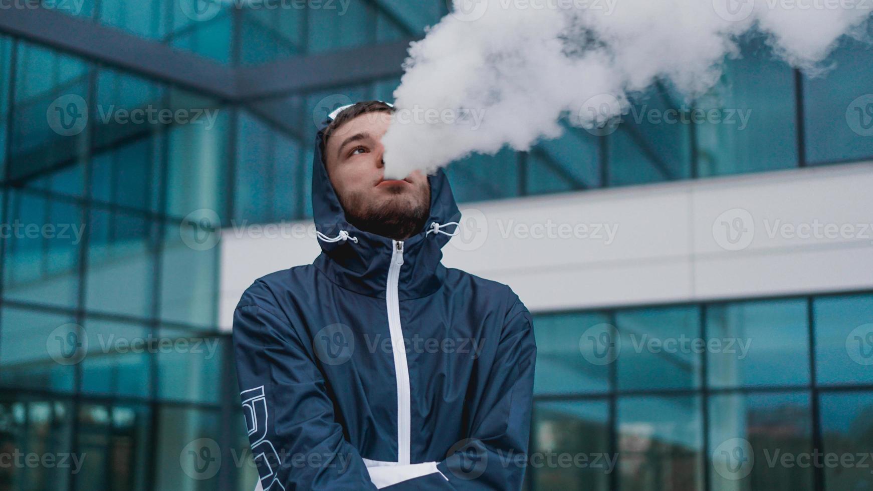 homme fumant de la vapeur de cigarette électronique. fumer une cigarette électronique photo