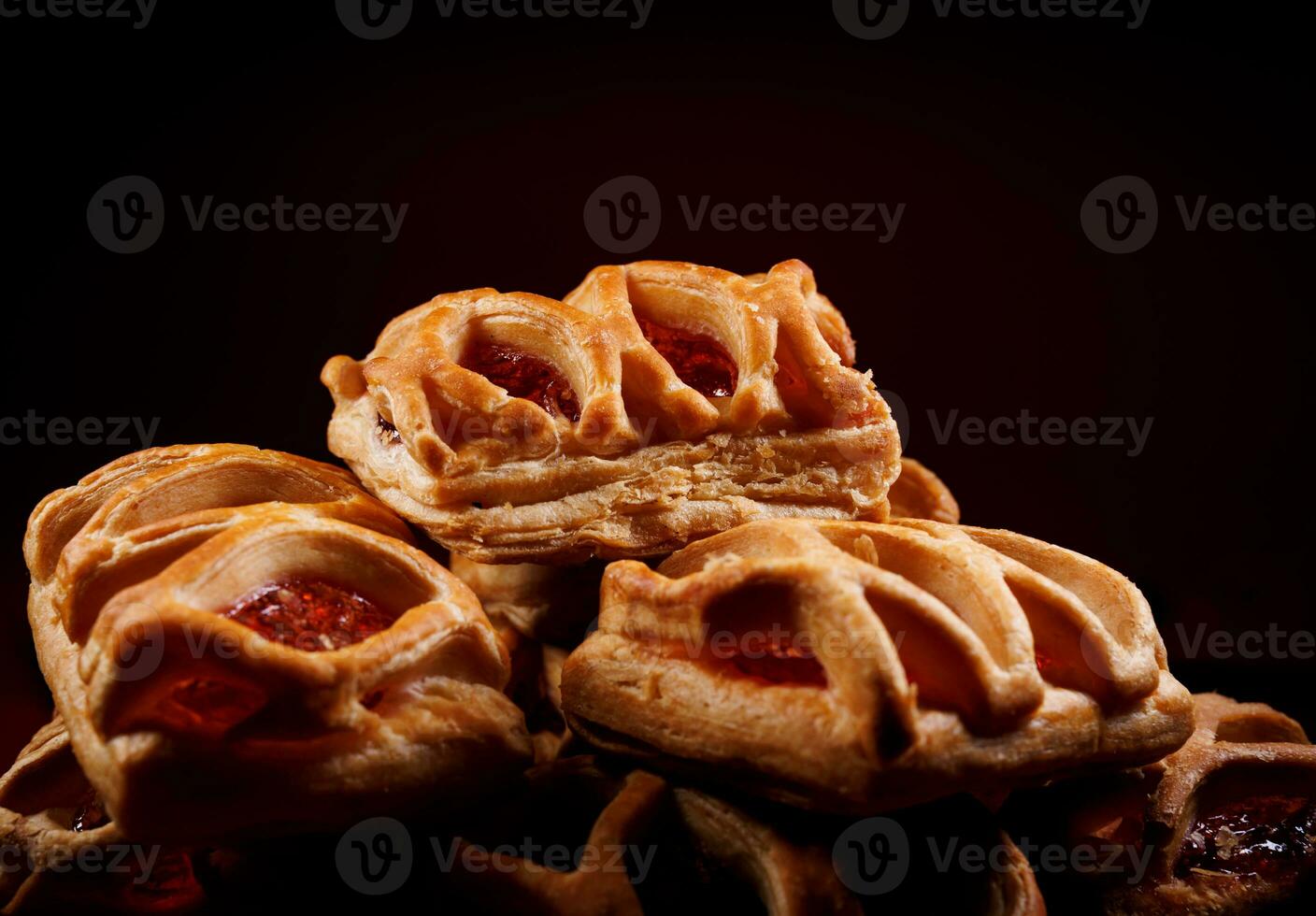 bouffée Pâtisserie Pâtisserie avec airelle confiture sur une foncé rouge Contexte. biscuits avec airelle Confiture. photo