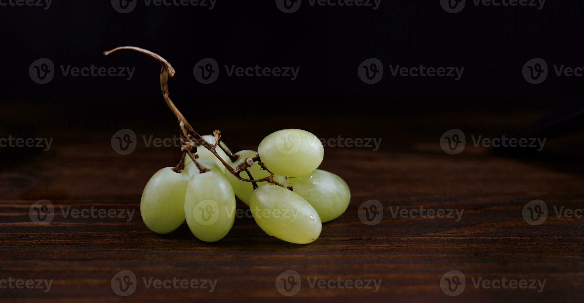 petit bouquet de mûr vert les raisins sur une en bois Contexte. photo