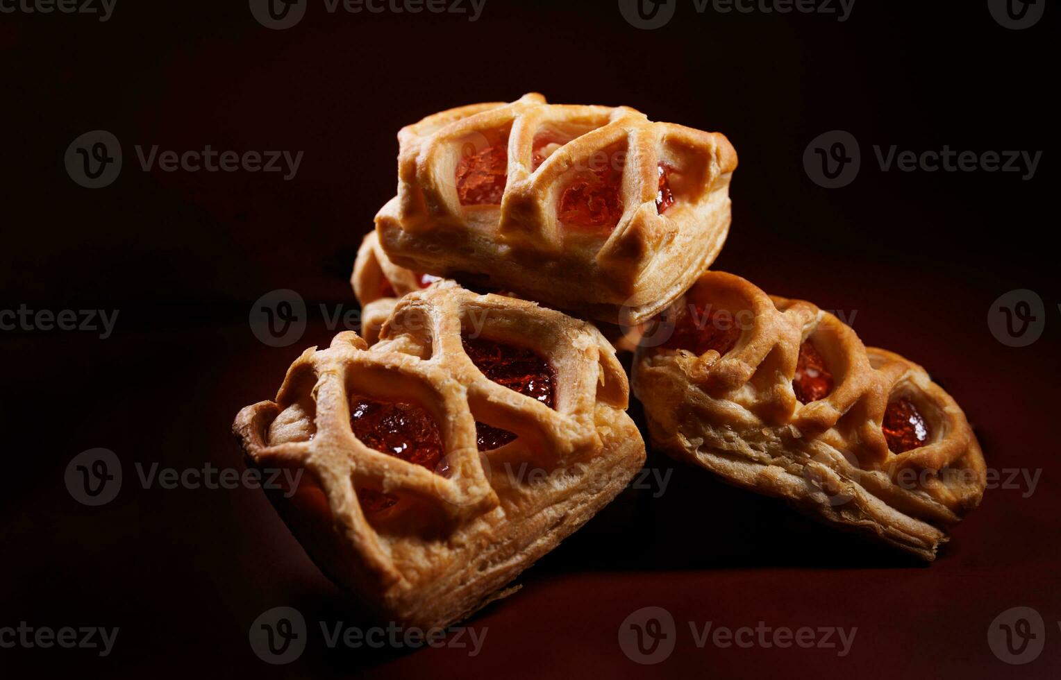 bouffée Pâtisserie Pâtisserie avec airelle confiture sur une foncé rouge Contexte. biscuits avec airelle Confiture. photo