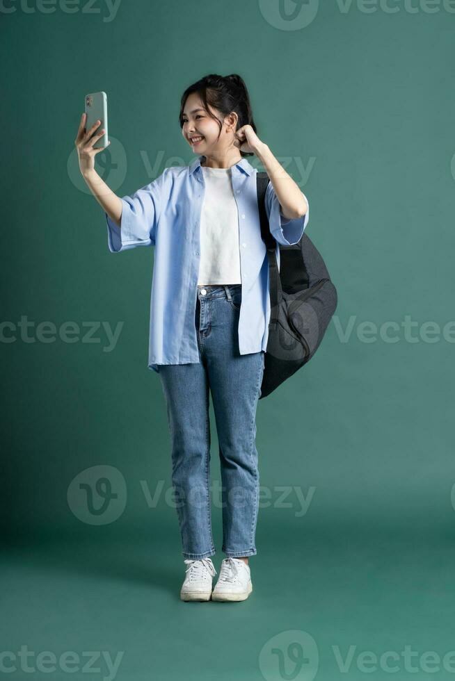 portrait de une magnifique asiatique étudiant sur une vert Contexte photo