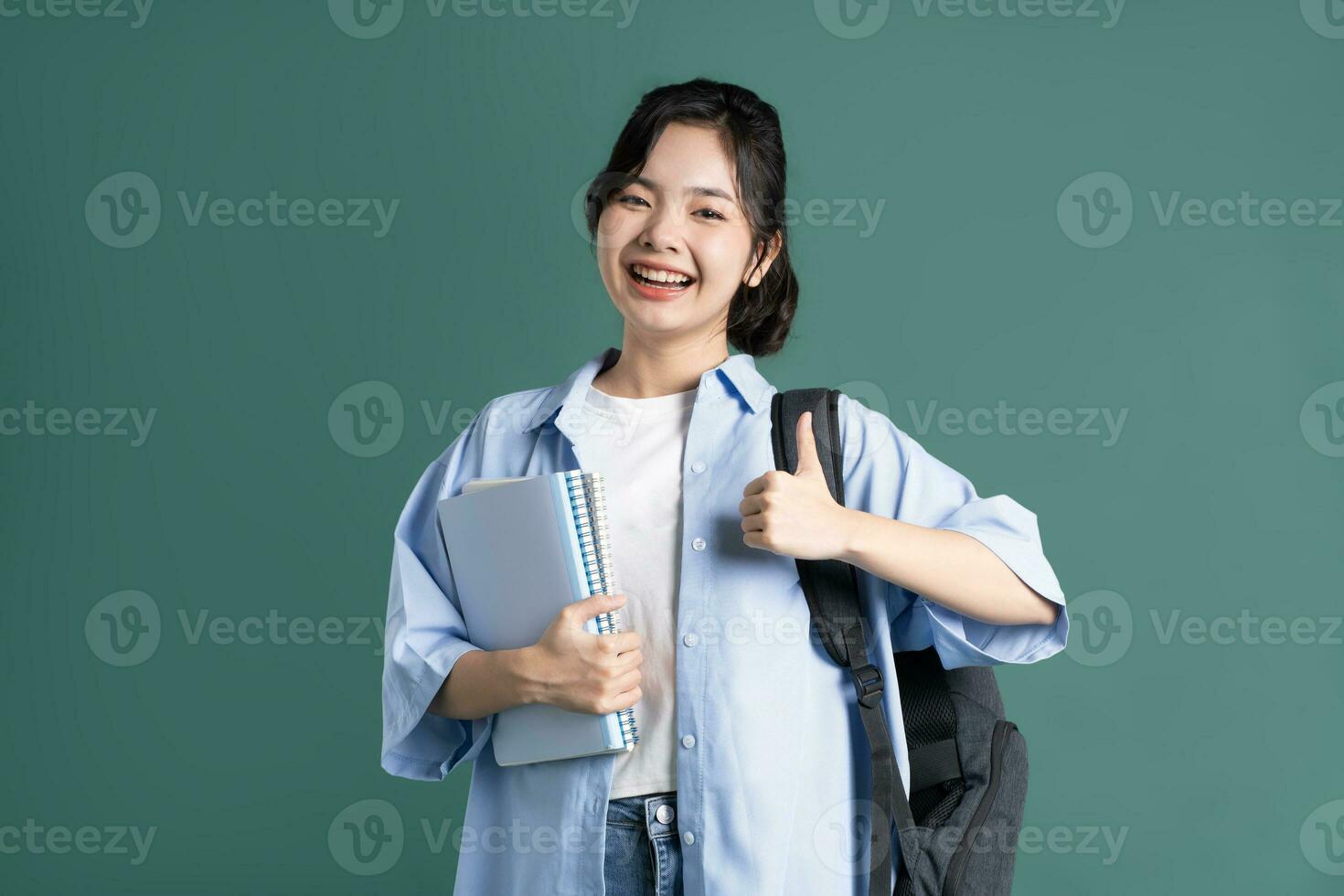portrait de une magnifique asiatique étudiant sur une vert Contexte photo
