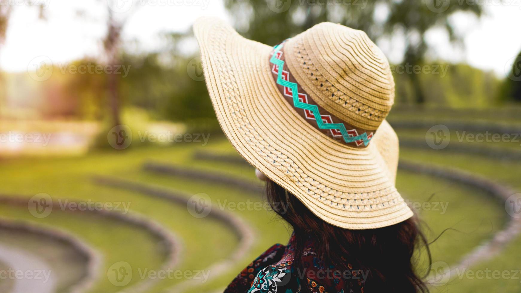 belle jeune femme en brillant à travers la robe touch chapeau de paille photo