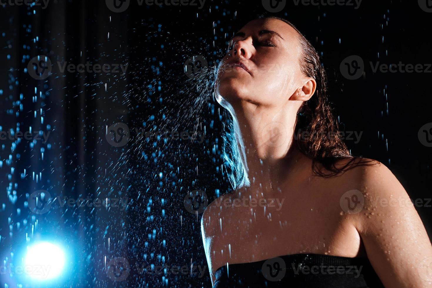 humide belle femme sous les gouttes de pluie qui tombent photo