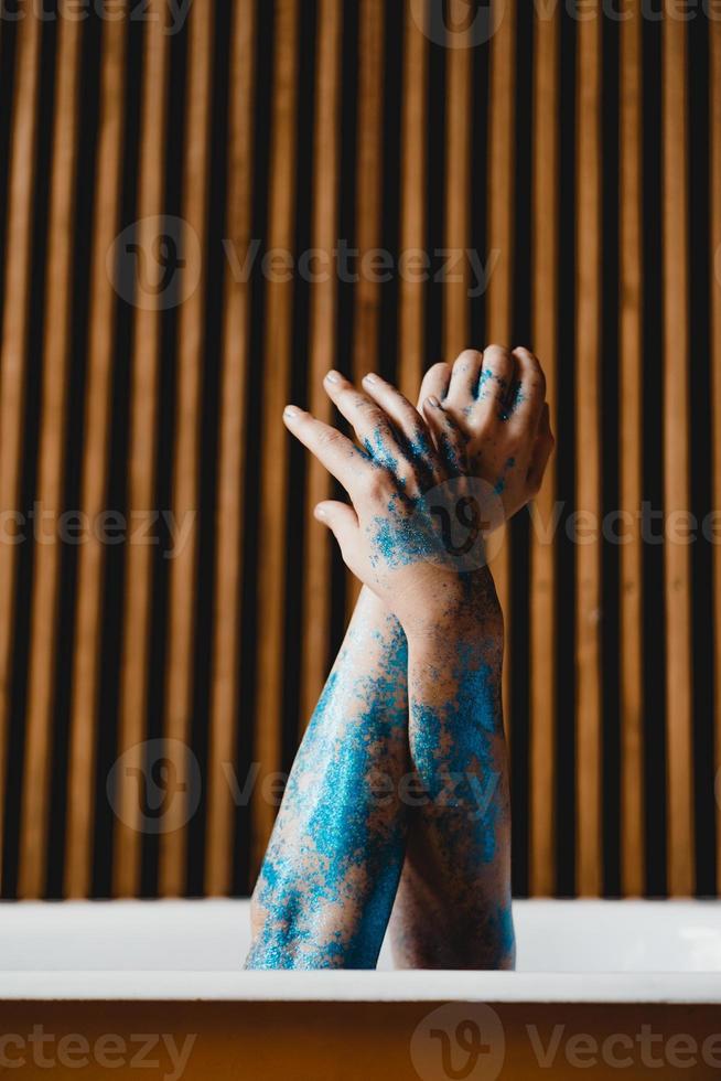 photo d'art. mains du bain jaune. peinture corporelle bleue sur les mains