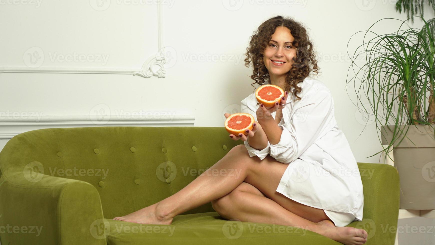 Portrait de jolie femme d'âge moyen aux cheveux bouclés avec pamplemousse photo